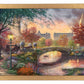 Framed painting of autumn in New York showing a bridge and trees by the river