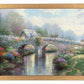 Framed painting of a bridge with blossoming trees and flowers